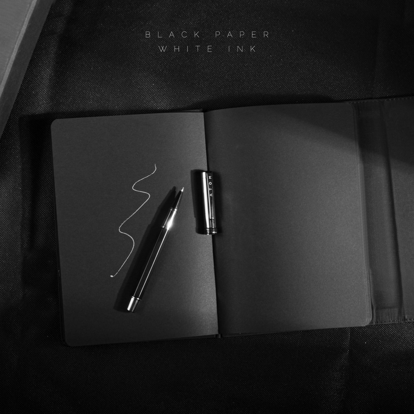 Black notebook and silver pen